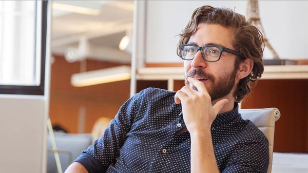 Professioneller Mann im modernen Büro, nachdenklich und inspiriert.