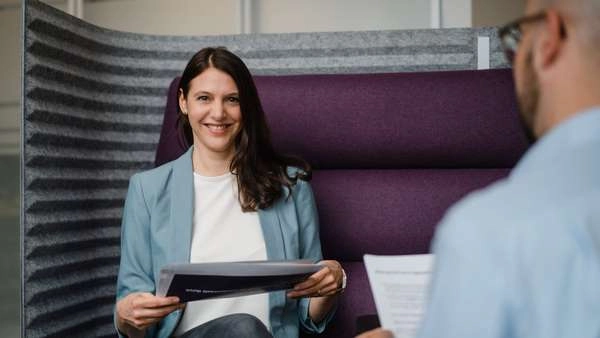 Professionelle Geschäftsfrau im Gespräch, lächelnd und engagiert.