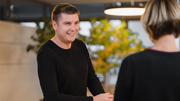 Moderne Büroatmosphäre mit lächelndem Mitarbeiter im Gespräch.