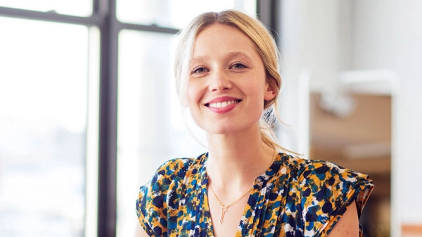 Moderne, lächelnde Frau in stilvollem Büro, inspiriert und professionell.